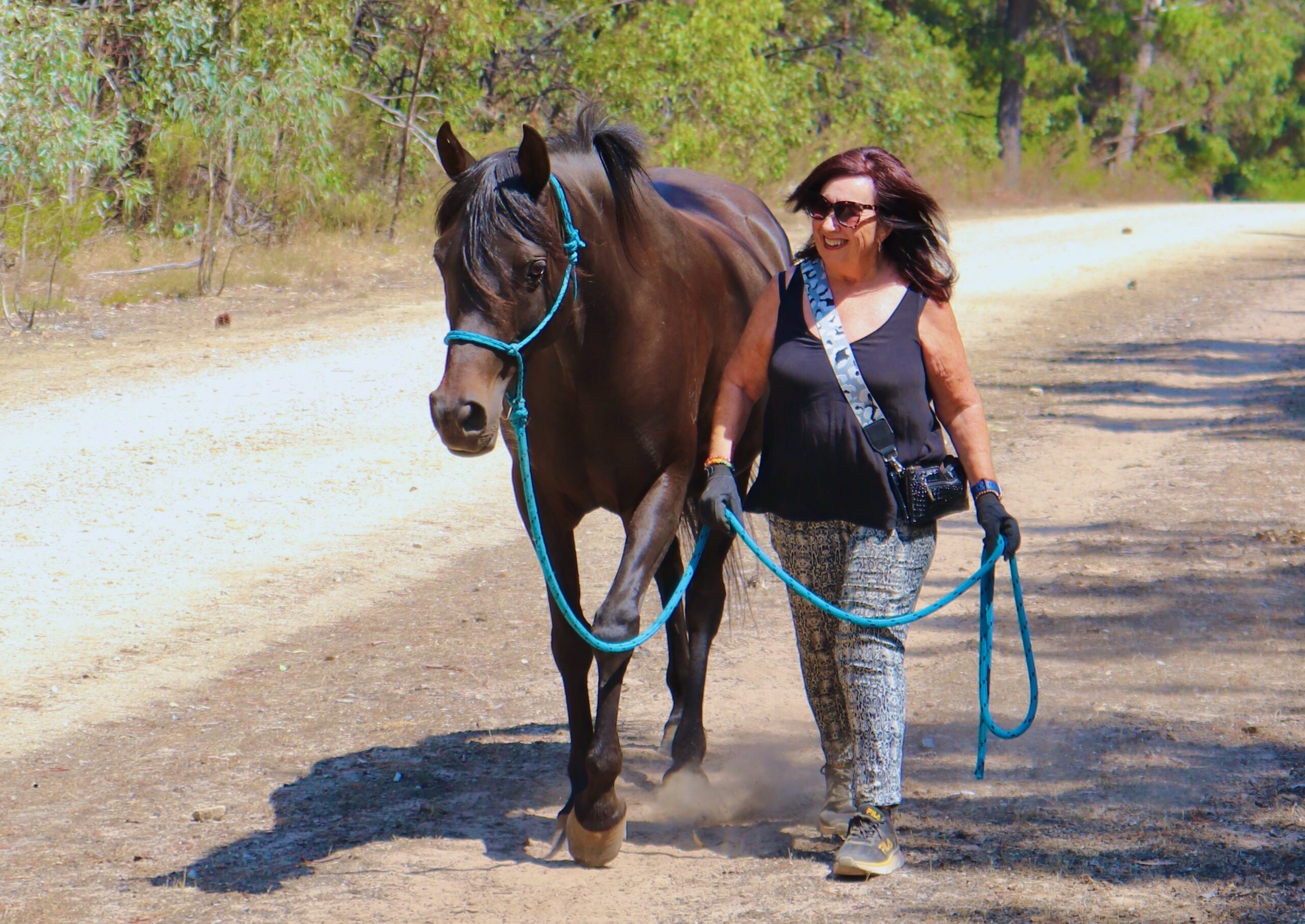 Cherish | Happy lady walking with a black horse